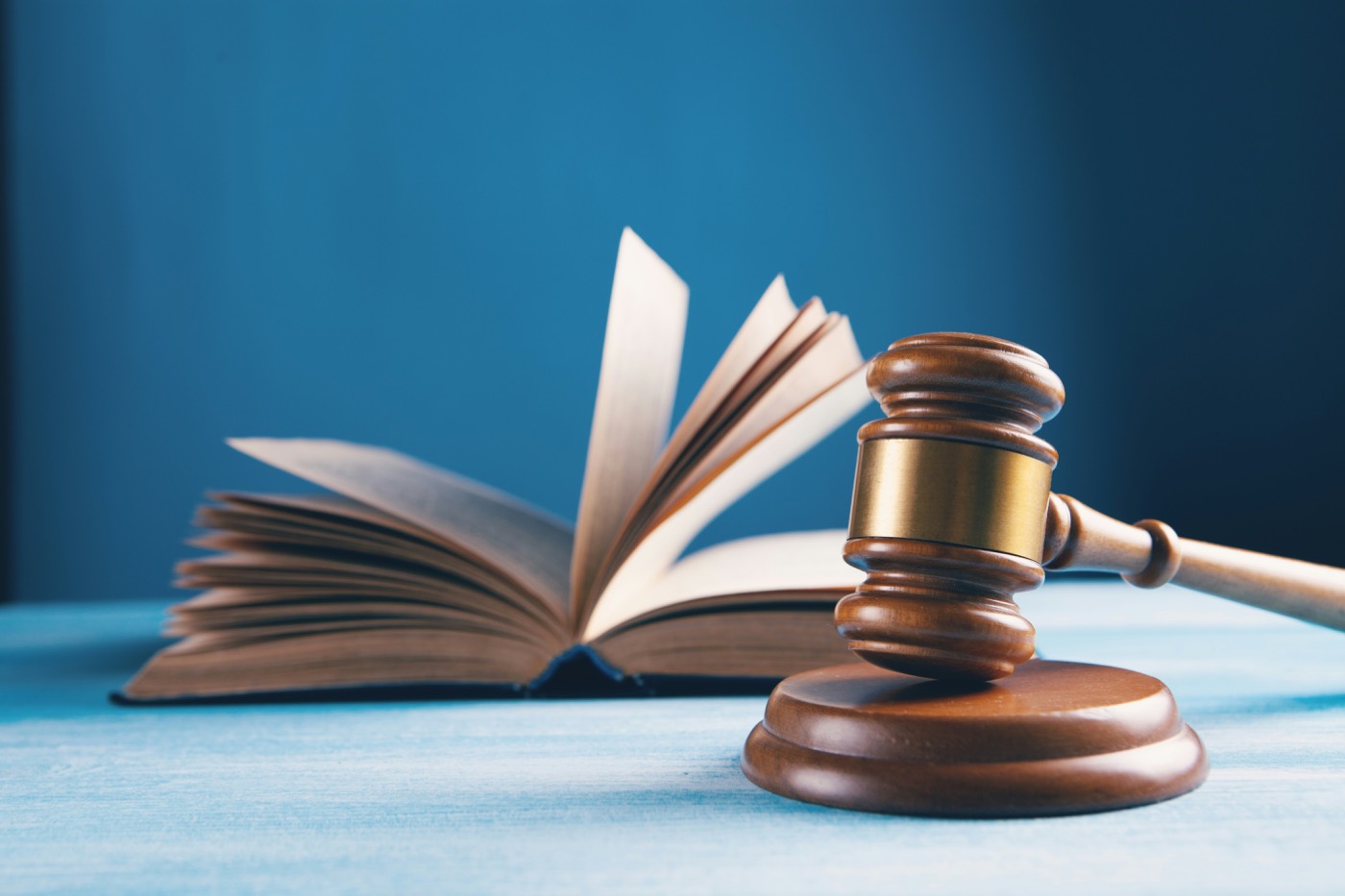 A gavel beside an open statute book, representing regulated-sector obligations